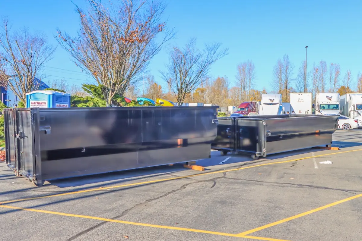 Professional dumpster rental service with roll-off container on residential driveway in Volney